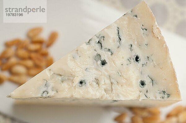 Ein Stück italienischer Gorgonzolakäse frisch geschnitten  und Pinienkerne