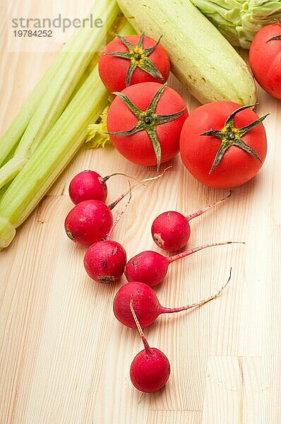 Frischer Rettich und Gemüse über Kiefernholztisch Großaufnahme