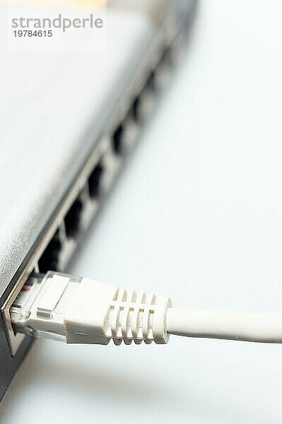 Netzwerk Hub Switch mit angeschlossenem Lan Kabel über weiß