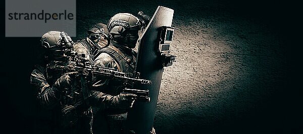 Bild von drei Soldaten in einem schießenden Computerspiel. ESports Konzept. Sie verstecken sich hinter einem taktischen kugelsicheren Schild. Gemischte Medien