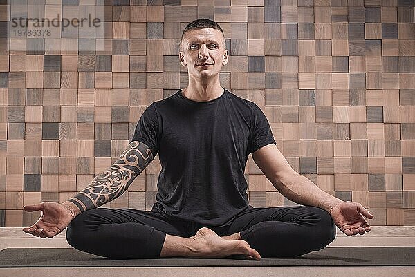 Erwachsener Mann führt Asana Übungen durch. Yoga Konzept. Sport und gesunder Lebensstil. Gemischte Medien