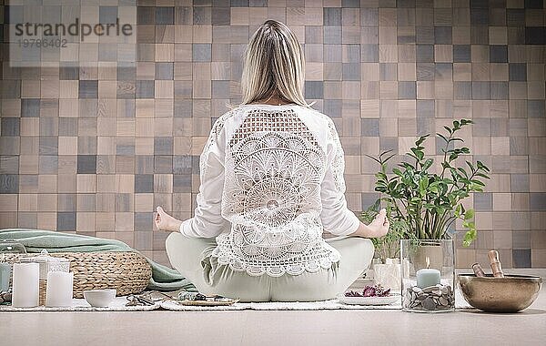 Bild einer erwachsenen Frau im Yogaraum. Meditation. Rückansicht. Das Konzept von Yoga und spirituellen Praktiken. Gemischte Medien