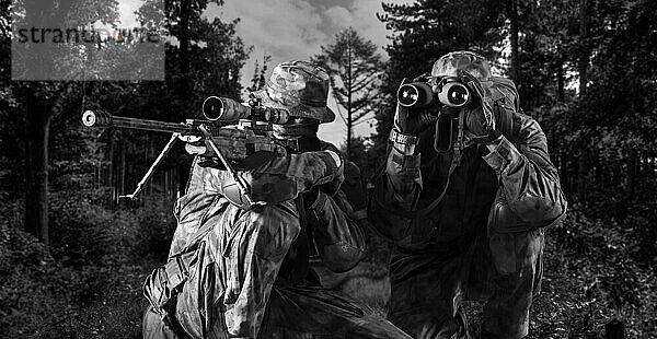Eine Gruppe von Scharfschützen mit einem Nachtsichtgerät verfolgt das Ziel. Gemischte Medien