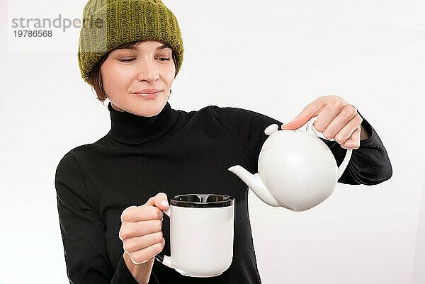 Porträt einer lächelnden Frau  die Tee aus einer weißen Teekanne einschenkt. Teezeremonie. Gemischte Medien