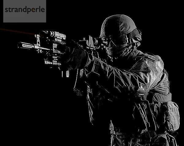 Amerikanischer Soldat in Kampfmunition mit einer Waffe  die mit einem Laservisier ausgestattet ist  zielt auf das Ziel. Gemischte Medien