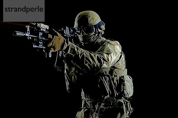 Amerikanischer Soldat in Kampfmunition mit einer Waffe  die mit einem Laservisier ausgestattet ist  zielt auf das Ziel. Gemischte Medien