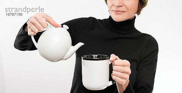 Porträt einer lächelnden Frau  die Tee aus einer weißen Teekanne einschenkt. Teezeremonie. Gemischte Medien