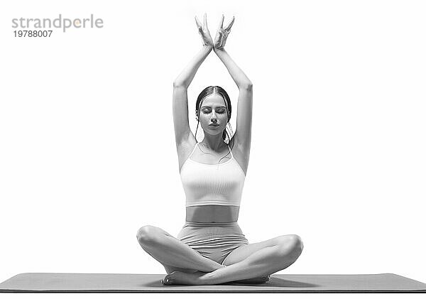 Sportliche junge Frau bei der Yoga Praxis. vor einem weißen Hintergrund. Das Konzept eines gesunden Lebensstils und eines natürlichen Gleichgewichts zwischen körperlicher und geistiger Entwicklung. Pilates  Stretching