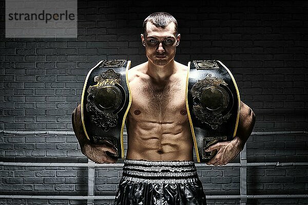 Der Weltmeister im Kickboxen im Mittelgewicht hat zwei Gürtel. Das Konzept des gesunden Lebensstils  des Sieges  des Erfolgs. Motivation. Gemischte Medien