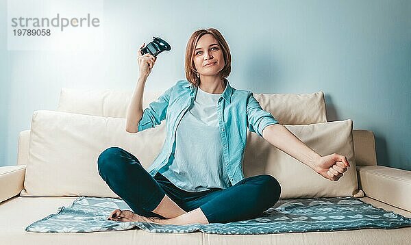 Mädchen mit einem Joystick in den Händen freut sich über den Sieg. ESports Konzept. Gemischte Medien