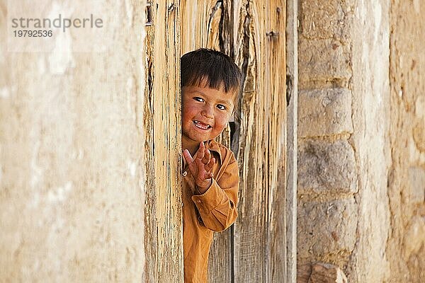 Fröhlicher bolivianischer Junge in einem Hauseingang in der Stadt Tarabuco  Provinz Yamparáez  Bolivien  Südamerika