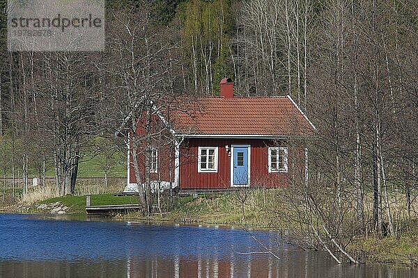 Schwedische rote Holzhütte am Fluss im Frühling  Värmland  Schweden  Europa