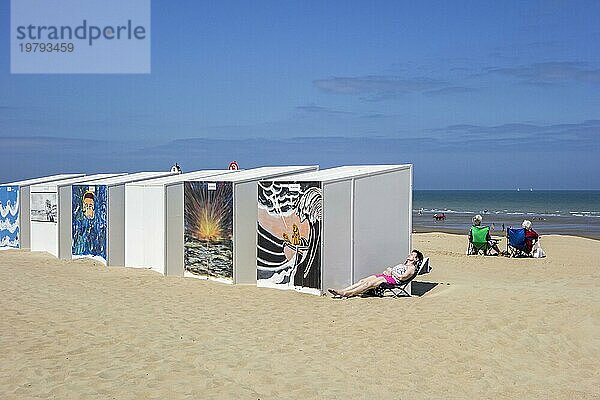 Geschmückte Strandhütten und ältere Frauen  die sich am Strand an der Nordseeküste sonnen