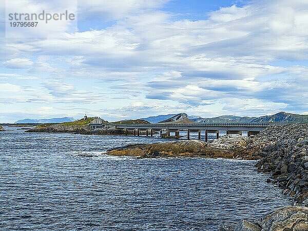Brücke verbindet felsige Ufer unter einem bewölkten Himmel  das Meer umspült sanft die Küste  Herbst  Atlantikstraße  Atlanterhavsveien  Romsdal  Norwegen  Europa