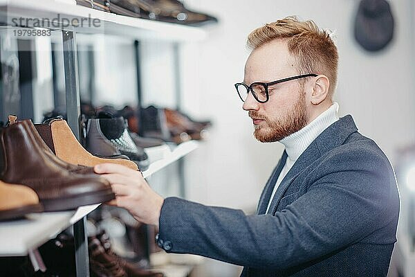Ein erfolgreicher Geschäftsmann wählt in einem Schuhgeschäft Schuhe für sich aus