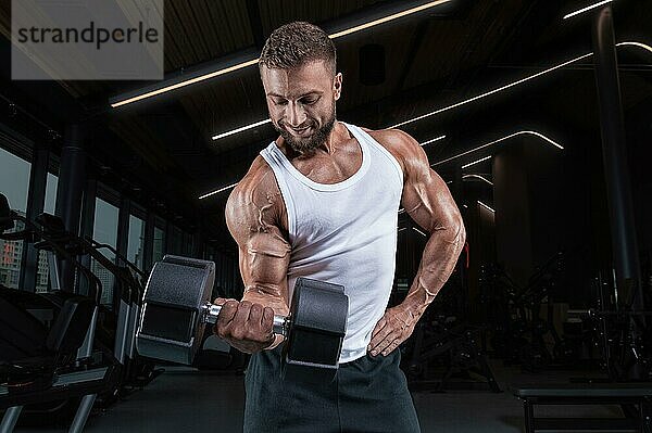 Bild von einem muskulösen Mann in einem weißen Trikot mit Sportgeräten. Fitnessstudio. Fitnesskonzept