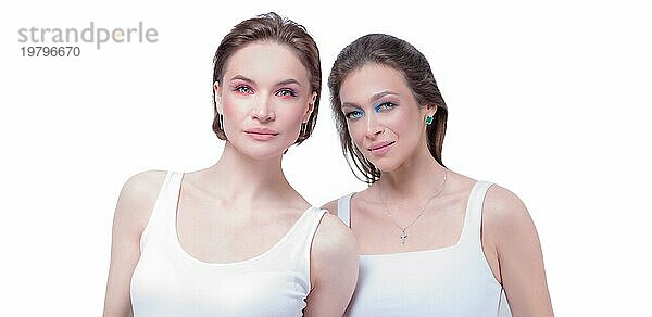 Porträt von zwei schönen Mädchen mit trotzigen Make up auf einem weißen Hintergrund. Weibliche Freundschaft Konzept. Hohe Qualität