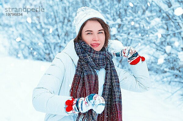 Porträt eines schönen Mädchens  das einen Schneeball wirft. Konzept für Weihnachtsferien  Winterspiele  Glück und Spaß. Gemischte Medien
