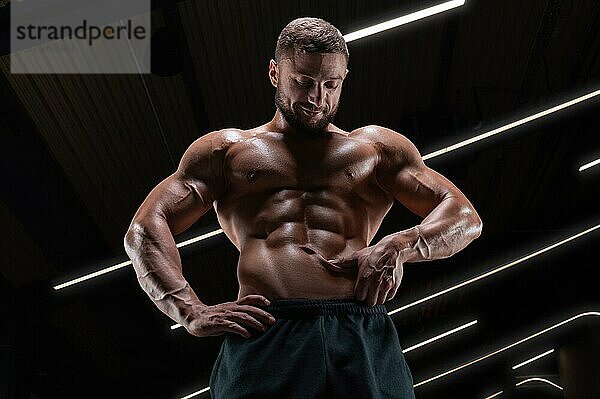 Bild eines muskulösen Mannes mit nacktem Oberkörper und Bauchmuskeln. Fitnessstudio. Fitnesskonzept
