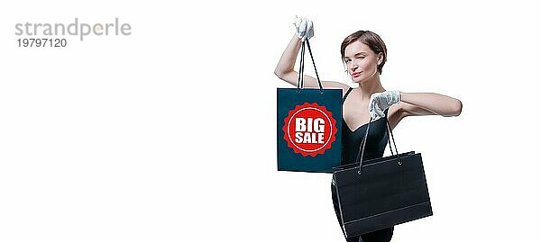 Ein elegantes großes Mädchen mit weißen Handschuhen zeigt ein schwarzes Luxuspaket. Das Konzept des sicheren Einkaufens während einer Pandemie