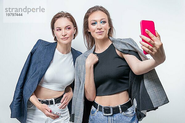 Porträt von zwei lachenden Frauen in Blazern  die ein Selfie machen. Konzept der Freundschaft.