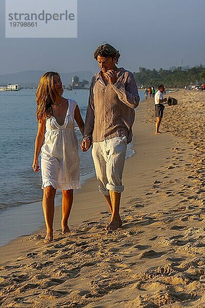 Junges Paar spaziert am Strand  Mann und Frau Hand in Hand