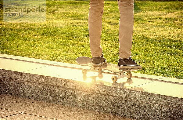Verzweifelter Skateboarder führt gefährliche Bewegung auf dem Skateboard bei Sonnenuntergang aus