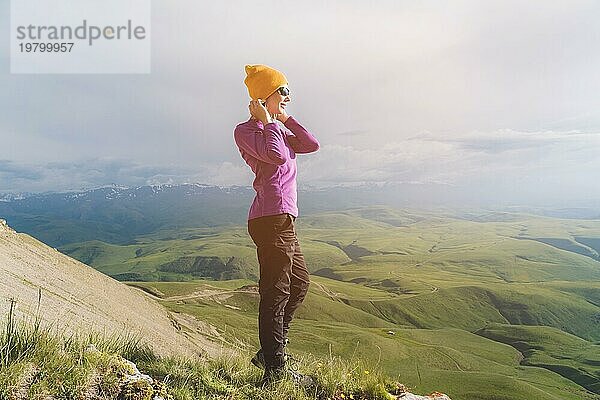 Ein Hipster Mädchen mit Strohhut und Brille in der Naturlandschaft