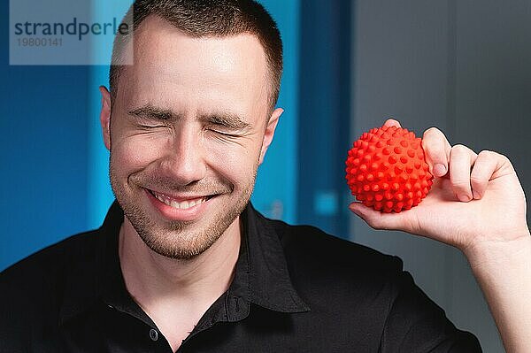 Porträt eines jungen kaukasischen Arztes  Physiotherapeuten und Masseurs mit einem Massageball in der Hand. Myofascial Release und Massage Ball Kopie Raum