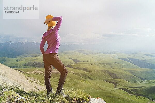 Ein Hipster Mädchen mit Strohhut und Brille in der Naturlandschaft