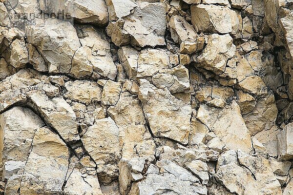 Kieselsteine in einer Felswand. Natürlicher Hintergrund einer Felsenmauer