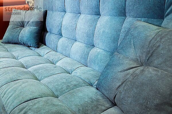 Nahaufnahme eines bequemen blaün Sofas mit gekräuselten Nähten. Modernes Design
