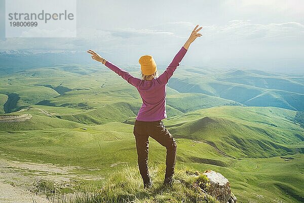 Junge Frau fühlt sich stark und zuversichtlich auf der Outdoor gegen grüne Tal