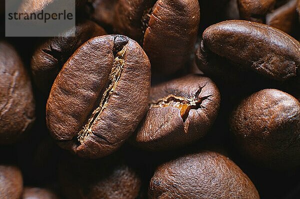 Close up extreme Makro Gruppe von gerösteten braunen oder schwarzen Kaffeebohnen Hintergrund in geringer Schärfentiefe. Betörendes Kaffeearoma