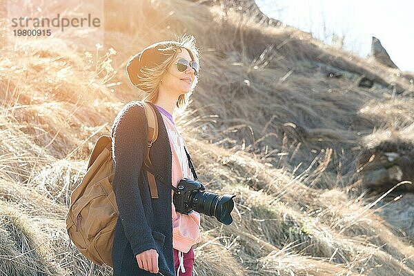 Frau Hipster Fotografin mit Spiegelreflexkamera. Stylish Mädchen in Sonnenbrille mit einer Kamera auf die Natur