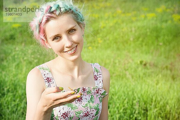 Porträt einer schönen Frau  die einen Schmetterling auf ihrer Hand im Garten hält. Porträt der Schönheit. Einheit mit der Natur. Ökologie Konzept