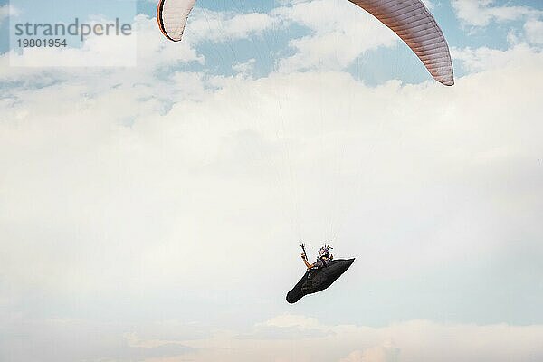 Alleine Gleitschirm fliegen in den blaün Himmel vor dem Hintergrund der Wolken. Paragliding in den Himmel an einem sonnigen Tag