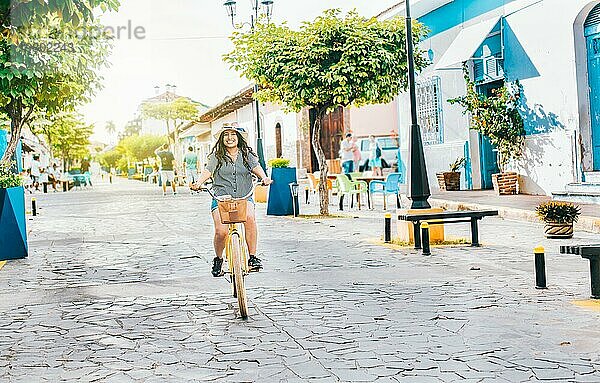 Junge Touristin auf dem Fahrrad in den Straßen von Granada  Nicaragua. Glückliches Touristenmädchen auf dem Fahrrad in der Straße Calzada
