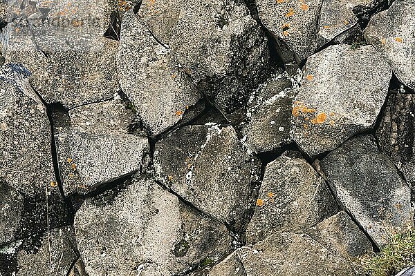 Texturierter Basalthintergrund Sechseckige Steinsäulen in einem Ausschnitt. natürliche vulkanische Formationen