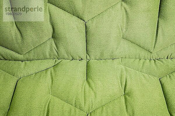 Nahaufnahme bequemes grünes weiches Sofa mit gekräuselten Nähten. Modernes Design