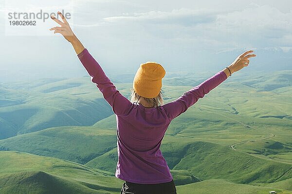 Junge Frau fühlt sich stark und zuversichtlich auf der Outdoor gegen grüne Tal