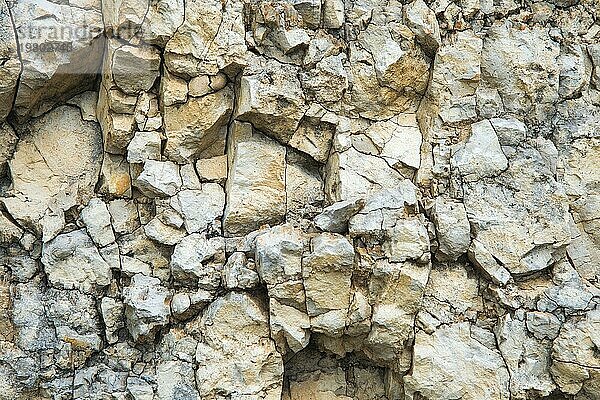 Kieselsteine in einer Felswand. Natürlicher Hintergrund einer Felsenmauer