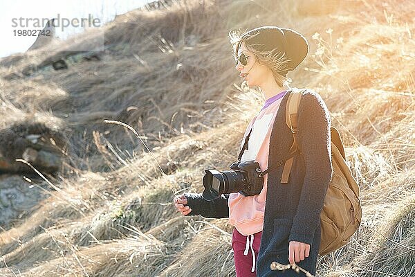 Frau Hipster Fotografin mit Spiegelreflexkamera. Stylish Mädchen in Sonnenbrille mit einer Kamera auf die Natur