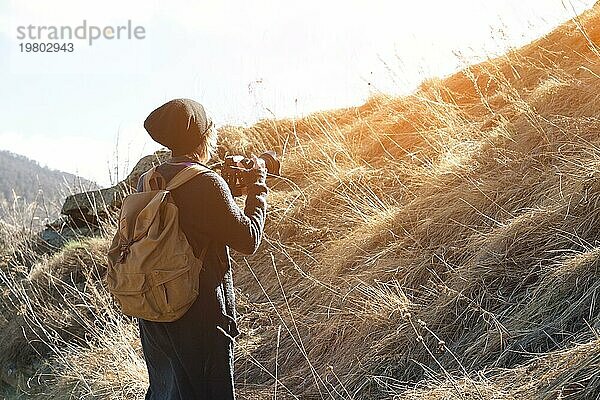 Frau Hipster Fotografin mit Spiegelreflexkamera. Stylish Mädchen in Sonnenbrille mit einer Kamera auf die Natur