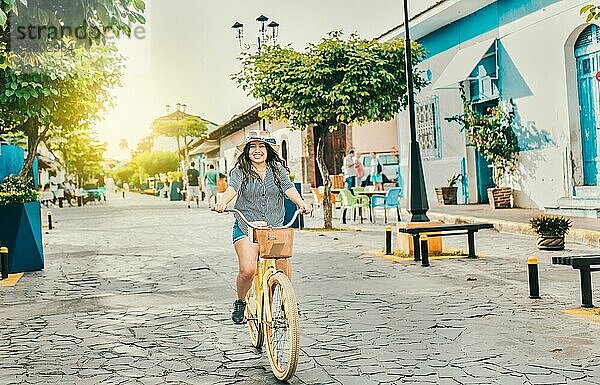 Lächelnde Touristin auf einem Fahrrad in den Straßen von Granada. Schönes Mädchen auf einem Fahrrad auf der Straße von La Calzada  Granada  Nicaragua  Mittelamerika