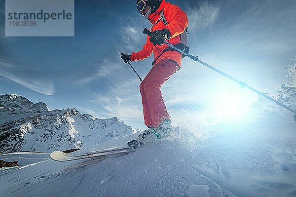 Nahaufnahme Skifahrer fährt auf einer verschneiten Piste an einem sonnigen Tag bei Sonnenuntergang vor der Kulisse der Berge. Das Konzept des Skifahrens im Winter