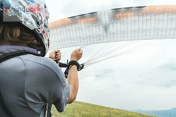 Nahaufnahme Der Gleitschirmflieger öffnet seinen Fallschirm  bevor er abhebt. Füllen des Fallschirmflügels mit Luft vor dem Abheben