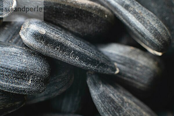 Nahaufnahme von schwarzen Sonnenblumenkernen. Textur  Hintergrund von natürlichen und gesunden Snacks. Makrofotografie mit geringer Schärfentiefe