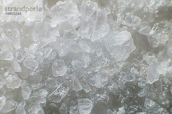 Makroansicht von Kristallen aus Kochsalz. Nützlicher Zusatzstoff für Kochsalzlösungen im Hintergrund mit geringer Tiefenschärfe. Nahaufnahme