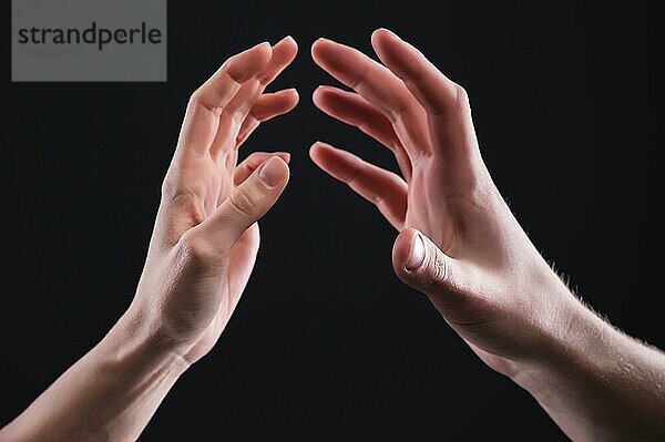 Eine Nahaufnahme von zwei Händen  Männchen und weiblich  die sich sanft berühren. Das Konzept der zittrigen Ablehnung zwischen den Geschlechtern. Warme Beziehungen zwischen Männern und Frauen